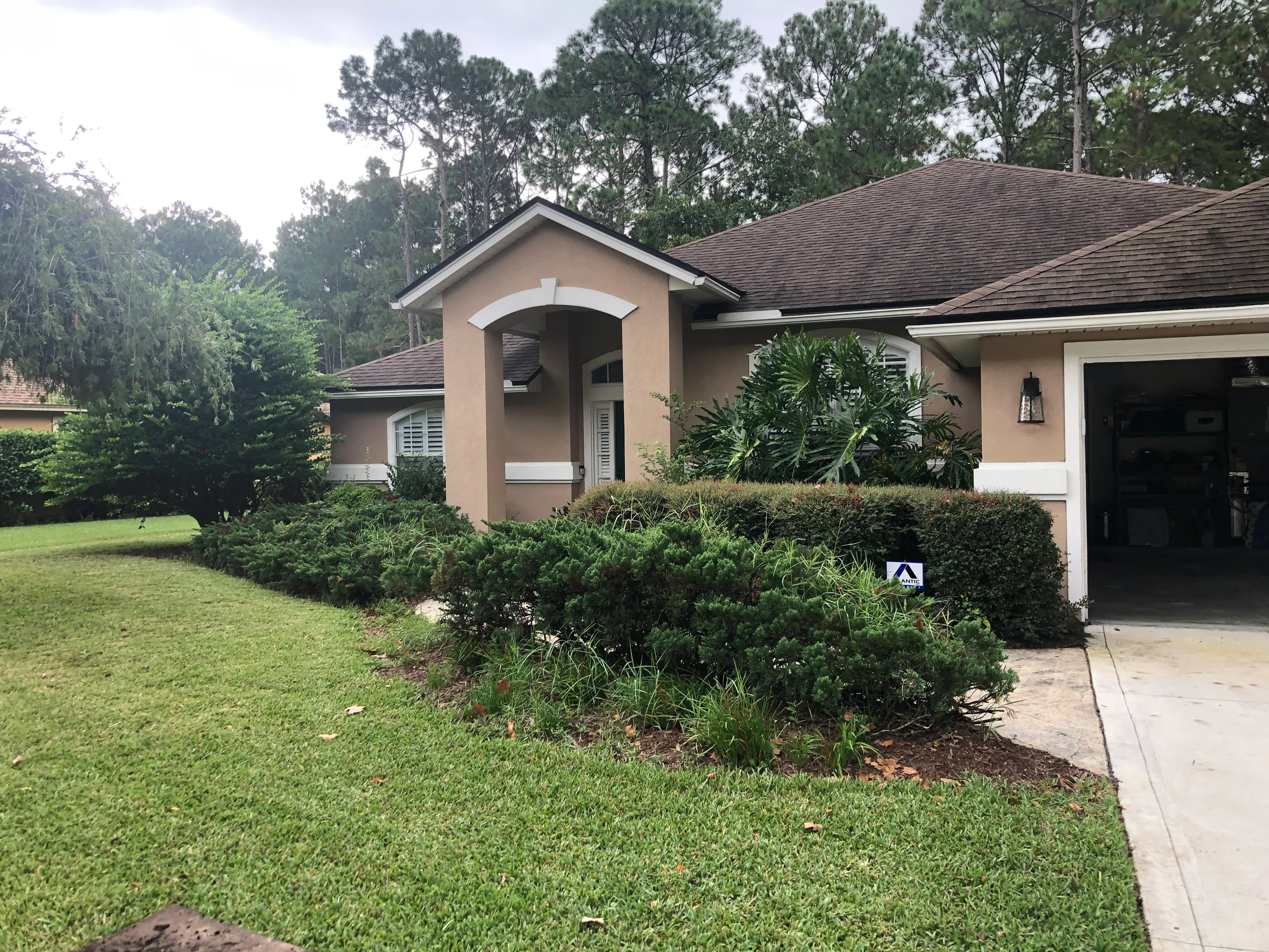 Front yard with installed shrub beds, mulch, mixed plantings, and maintained lawn